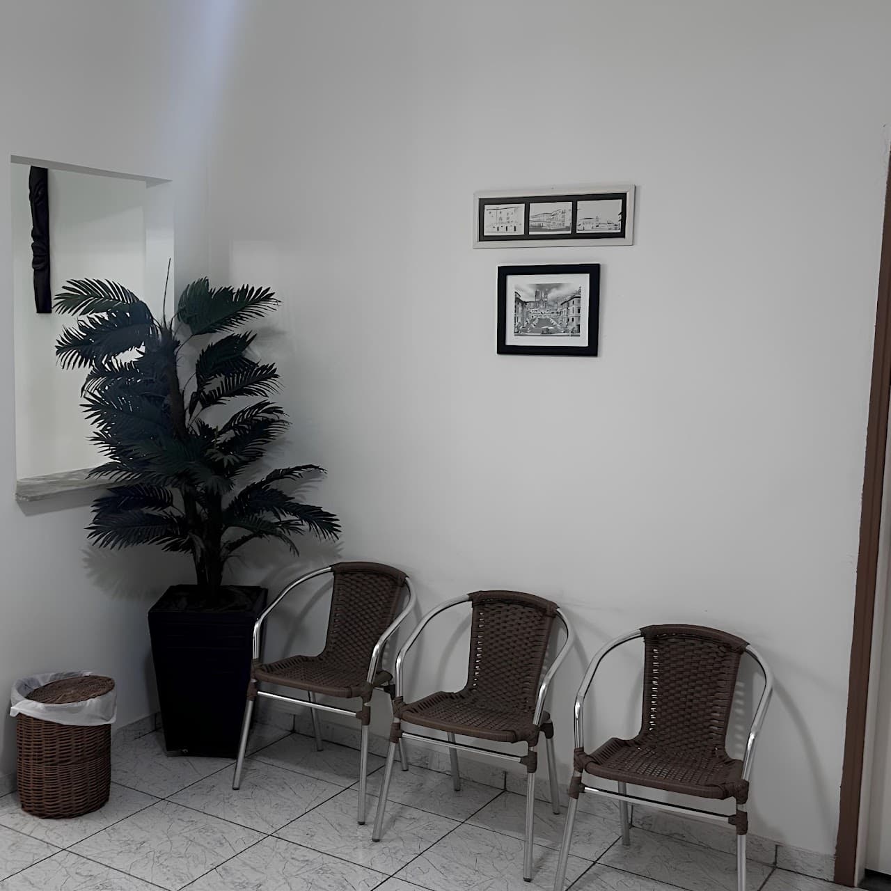 Recepção - três cadeiras em palha trançada marrom escuro, planta decorativa e quadros na parede